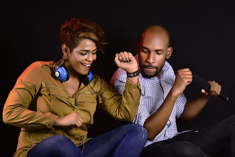 woman in brown jacket sitting beside man in blue and white checkered dress shirt